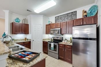 A kitchen with stainless steel appliances and granite counter tops